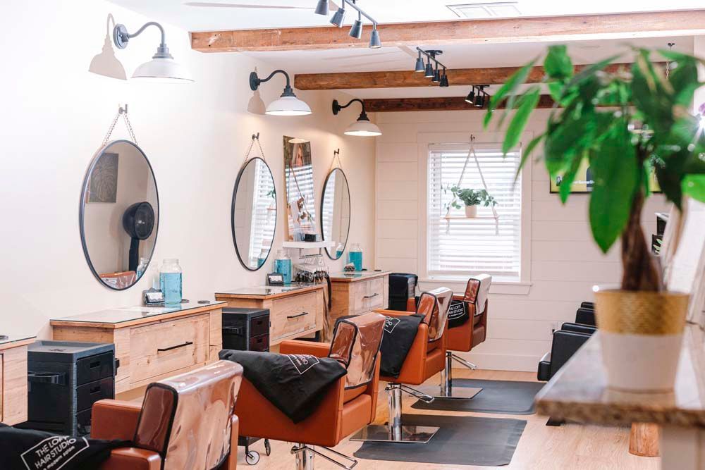 A hair salon with a lot of chairs and mirrors.