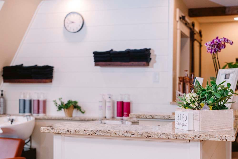 A salon with a sink , counter , and a clock on the wall.