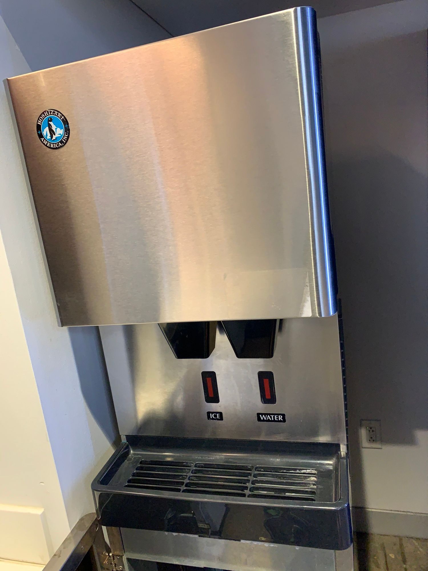 a stainless steel water dispenser is sitting on a counter .