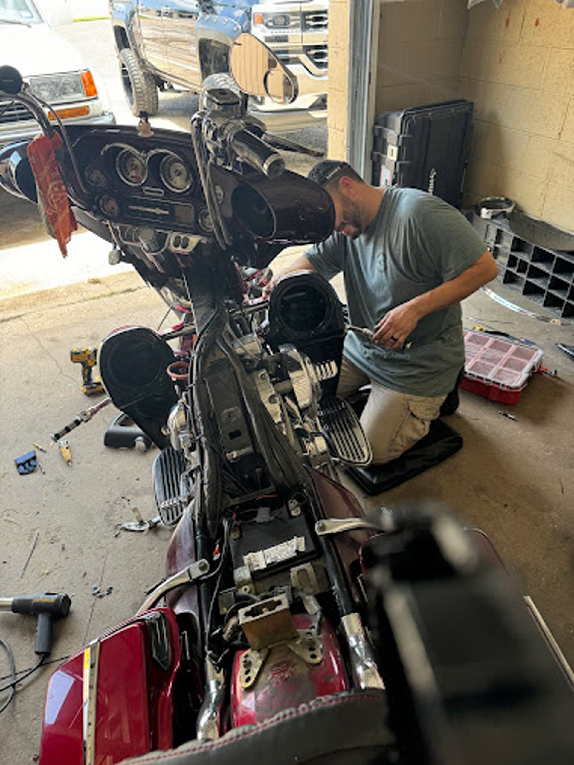 A man is working on a motorcycle in a garage