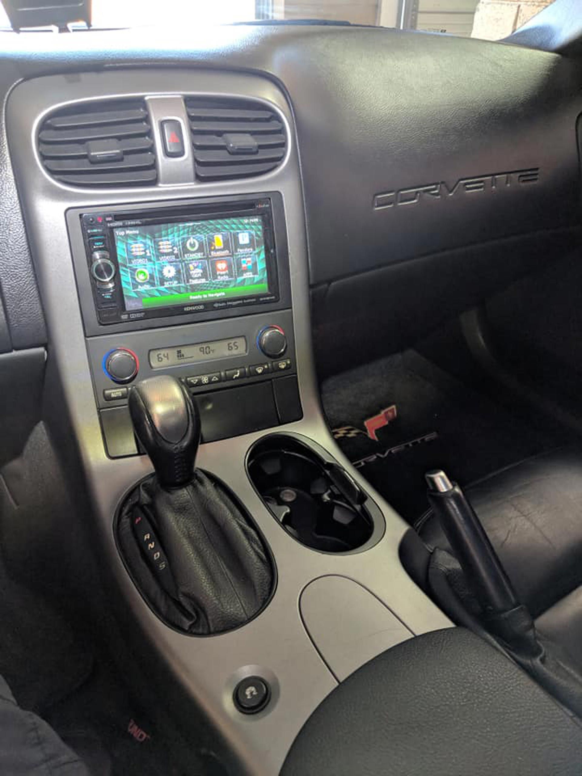 The interior of a corvette with a radio and a cup holder