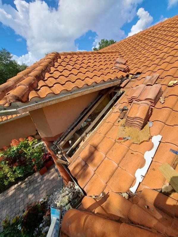 A roof with a lot of tiles on it is being repaired.