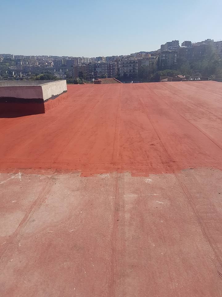 Un grande tetto rosso con una città sullo sfondo.