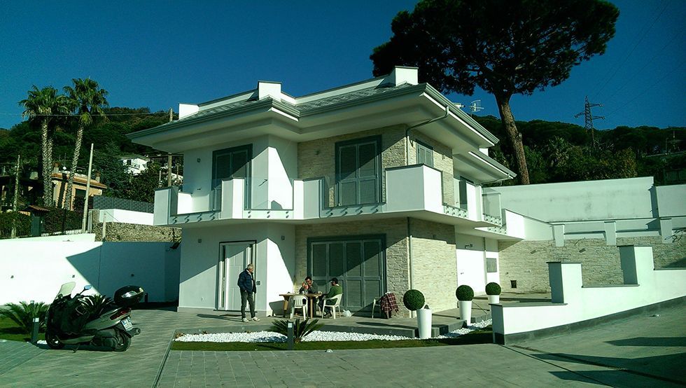 Una grande casa bianca con una moto parcheggiata di fronte