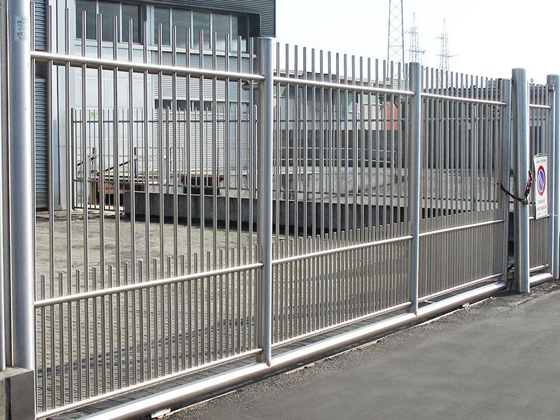 Un cancello in acciaio inossidabile si trova di fronte a un edificio.