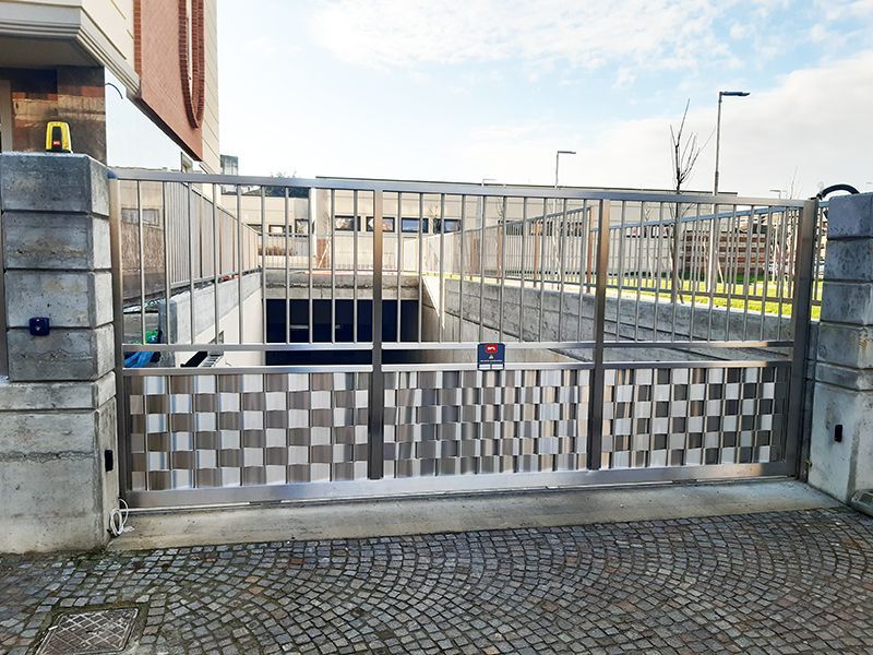 Un cancello in acciaio inox è aperto ad un garage.