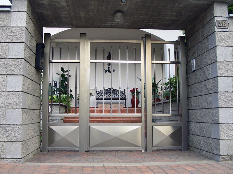 Un cancello in acciaio inossidabile davanti a un edificio in mattoni