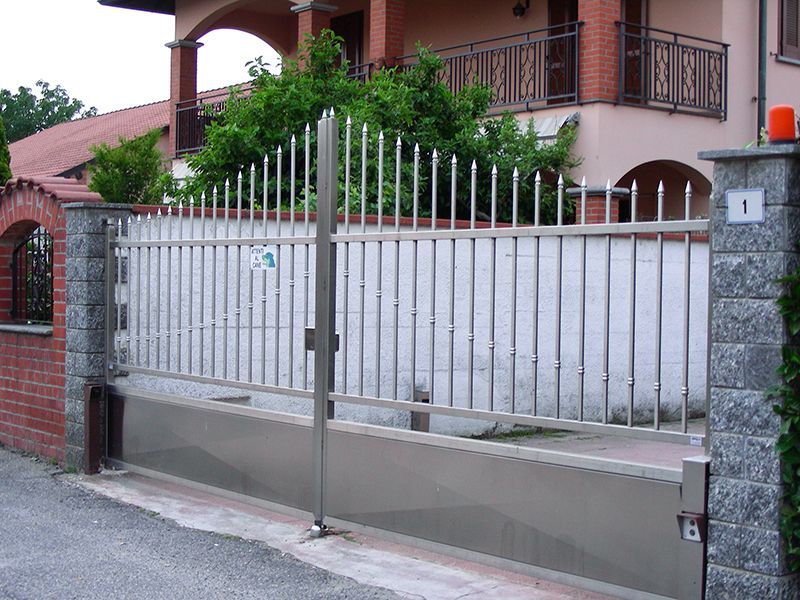 Davanti a una casa è aperto un cancello in acciaio inox