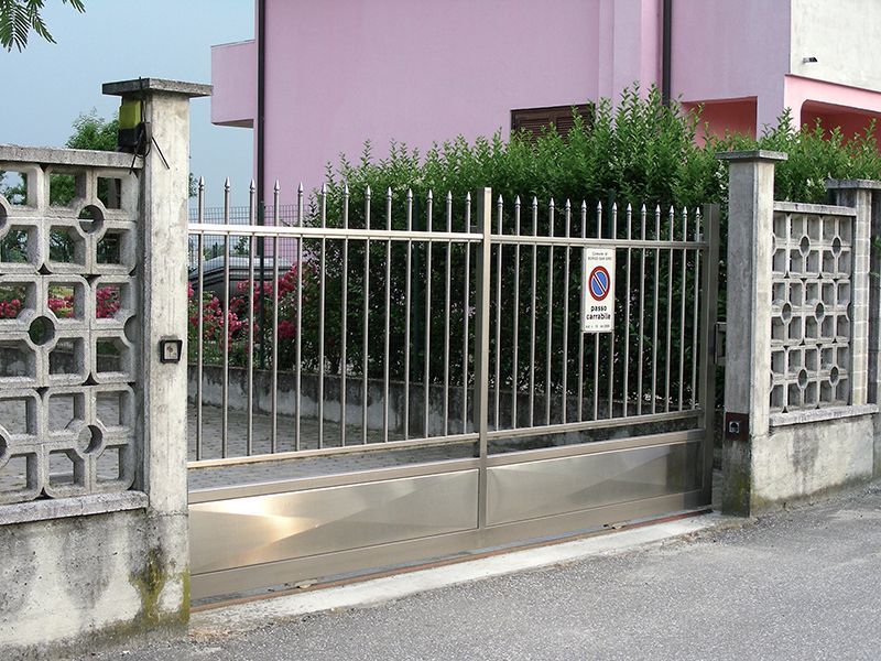 Un cancello in acciaio inossidabile con un cartello di divieto di parcheggio
