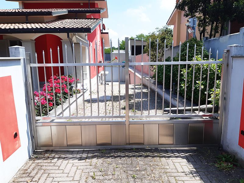 Davanti a una casa è aperto un cancello in acciaio inox