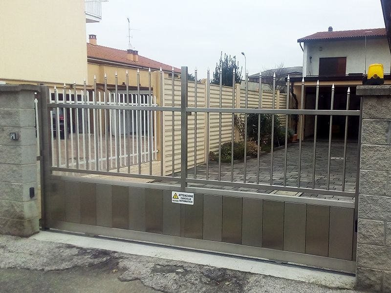 Davanti a una casa è aperto un cancello in acciaio inox