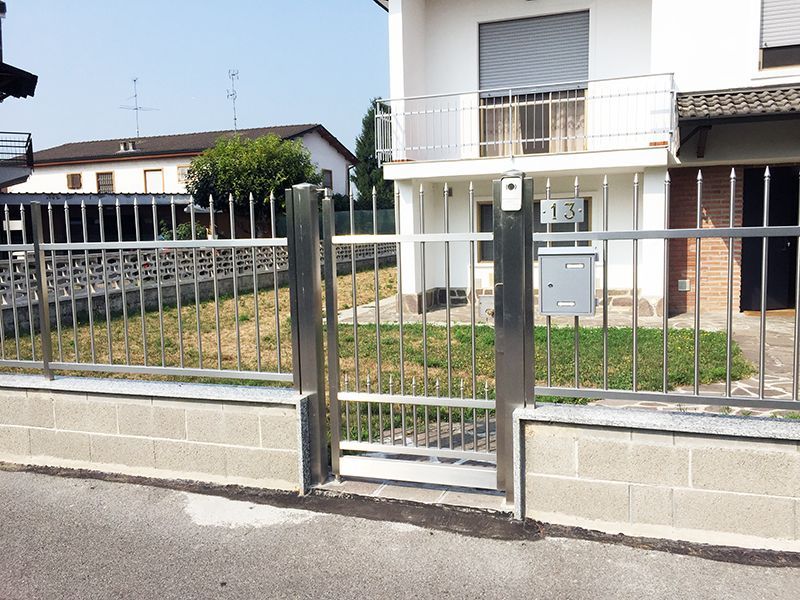 Una recinzione in acciaio inossidabile circonda una casa bianca