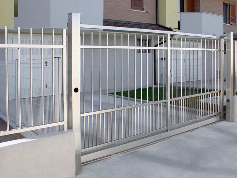 Una recinzione in acciaio inox con cancello scorrevole davanti a una casa