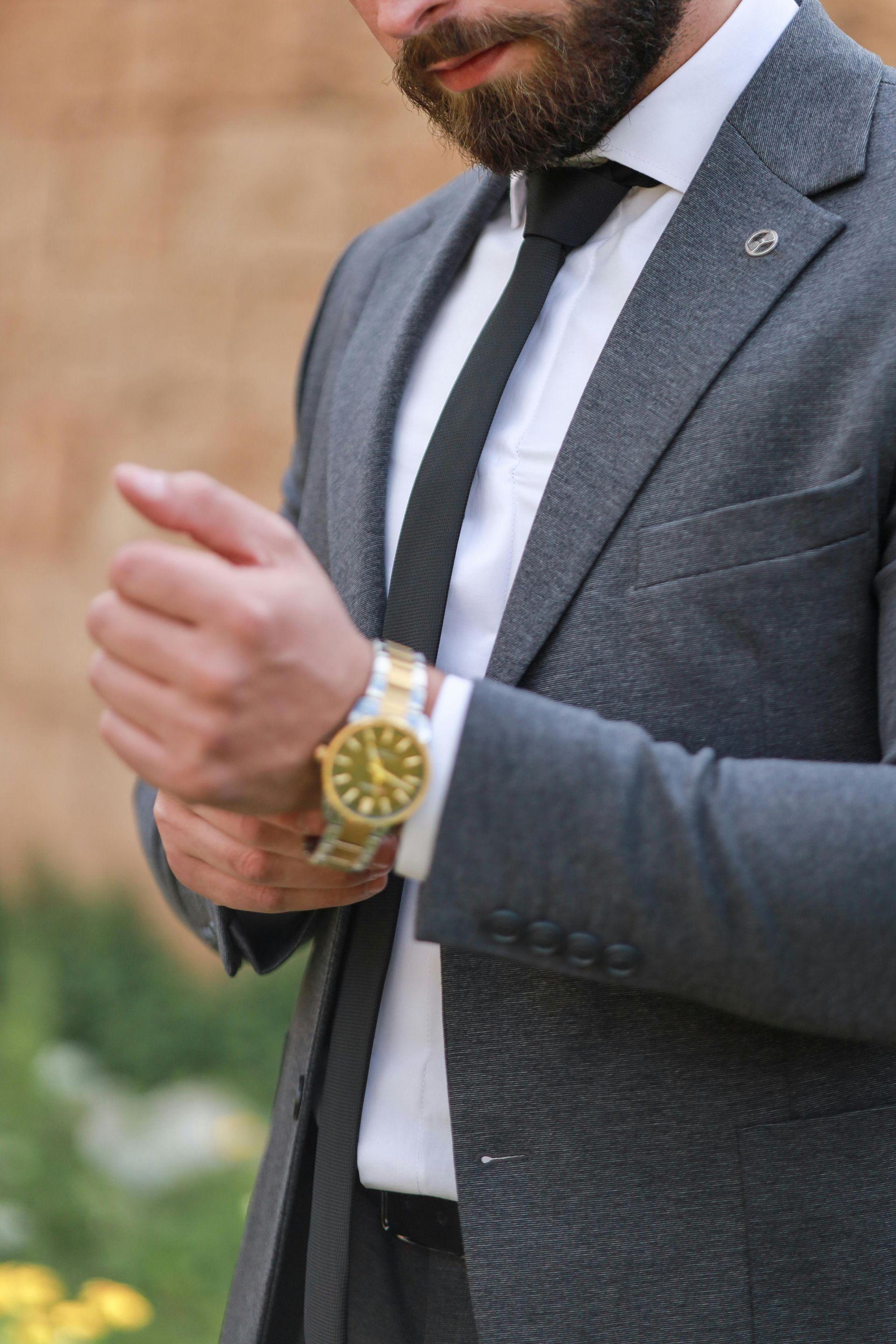 A man in a suit and tie is adjusting his watch