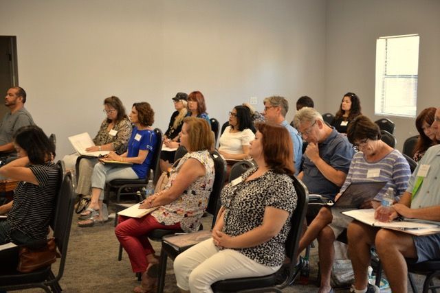A group of people are sitting in chairs in a room.