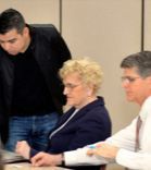 A group of people are sitting at a table in a conference room.
