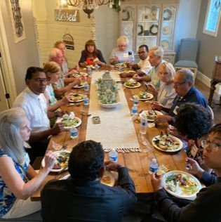 A group of people are sitting at a long table eating food.
