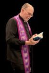 A church leader reading from a prayer book.