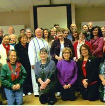 A large group of people are posing for a picture in a room.