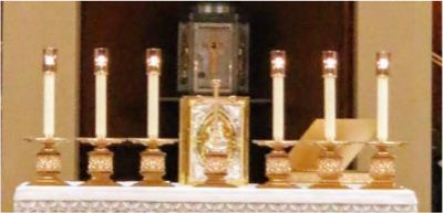 A church altar with candles and a picture of jesus on it