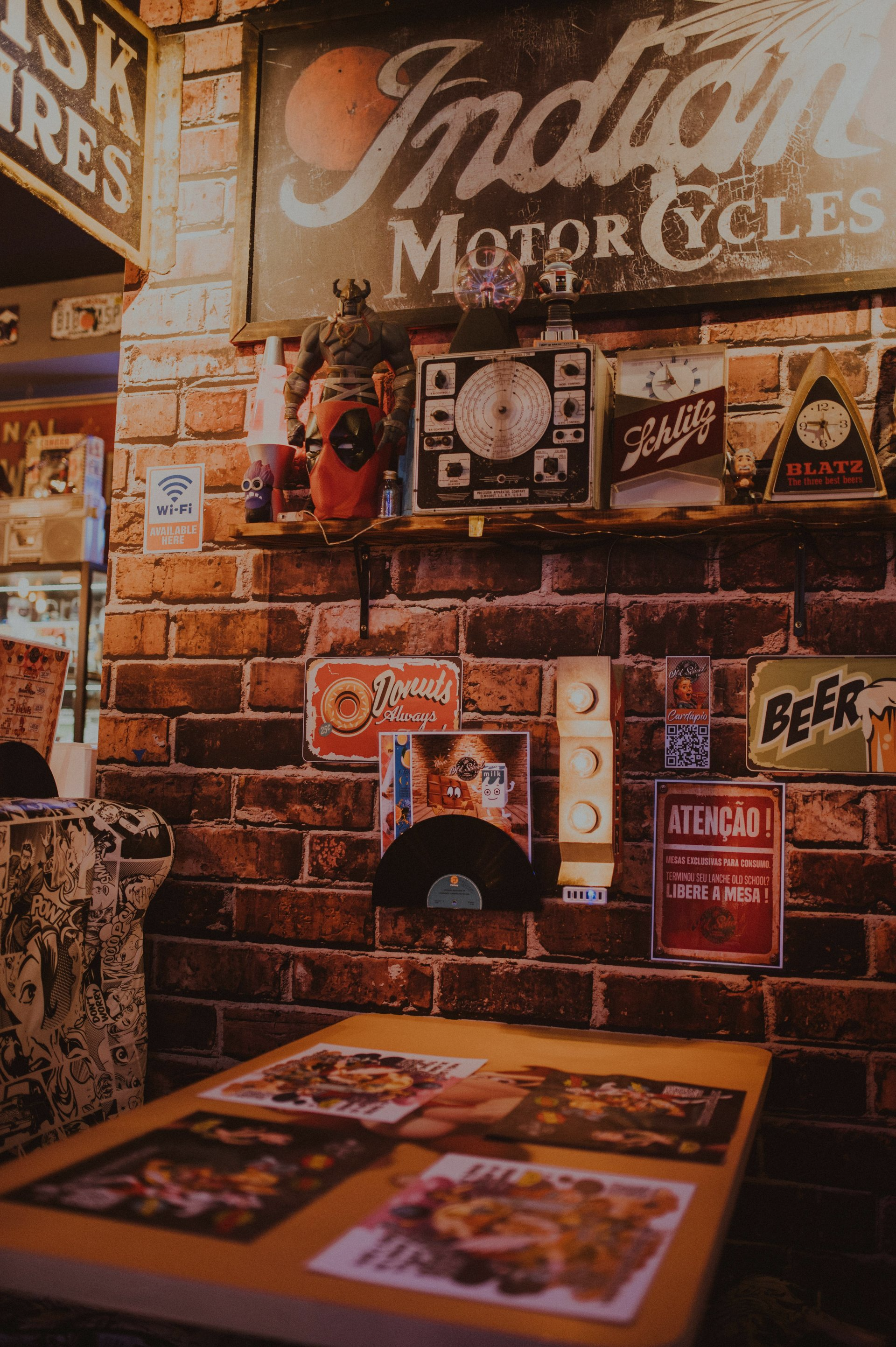 Restaurant interior with brick wall, vintage signs, and table with menu.