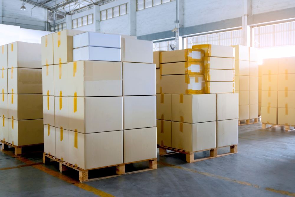 A Warehouse Filled With Lots of Cardboard Boxes on Wooden Pallets — AKM Self Storage In Kurri Kurri, NSW