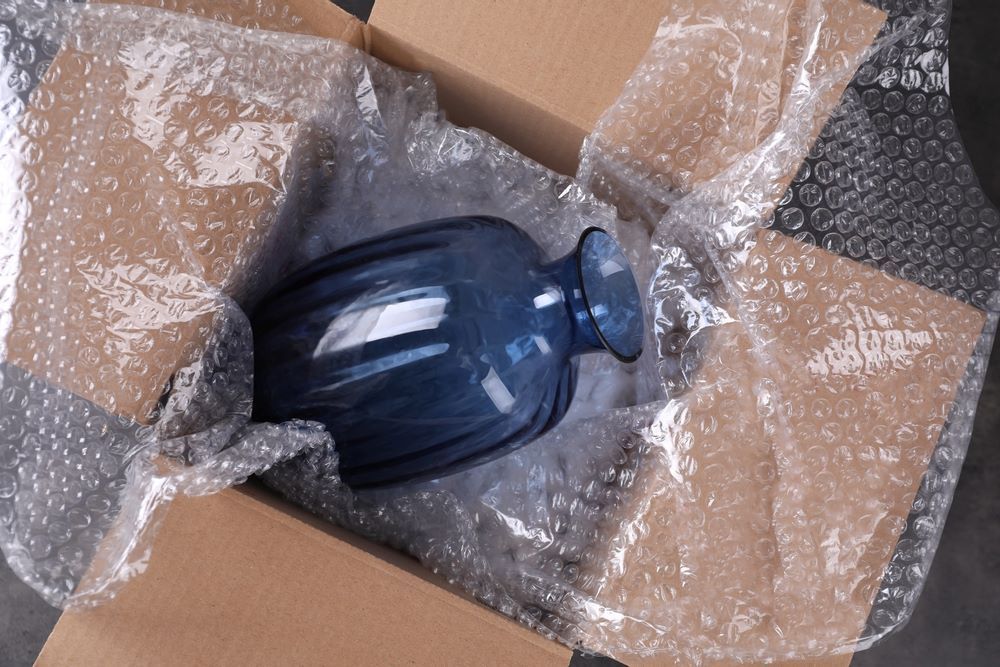 A Blue Vase is Wrapped in Bubble Wrap in a Cardboard Box — AKM Self Storage In Kurri Kurri, NSW