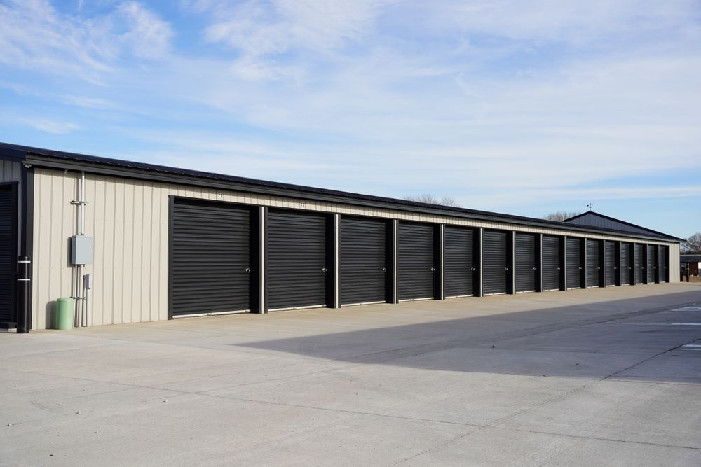 A Row of Storage Units With Black Doors on a Sunny Day — AKM Self Storage In Huntlee, NSW