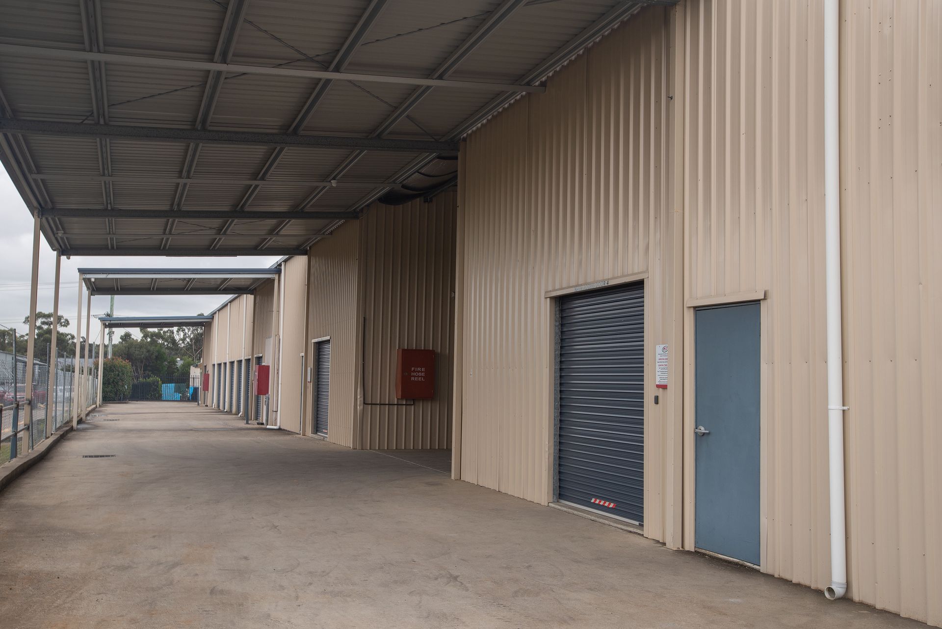 An Empty Building With a Roller Shutter on the Side of It — AKM Self Storage In Kurri Kurri, NSW