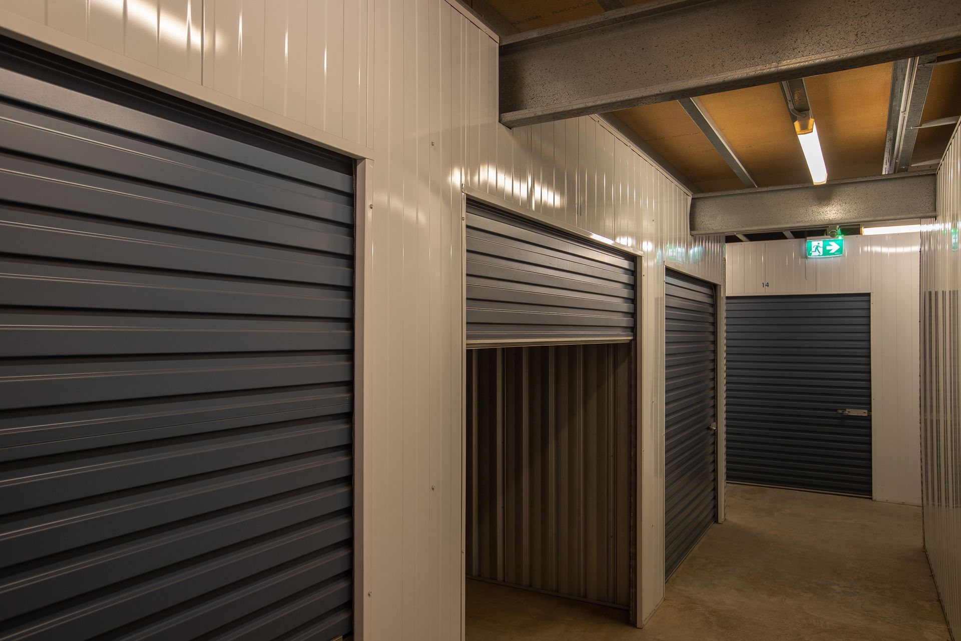 A Row of Garage Doors in a Warehouse at Night — AKM Self Storage In Kurri Kurri, NSW