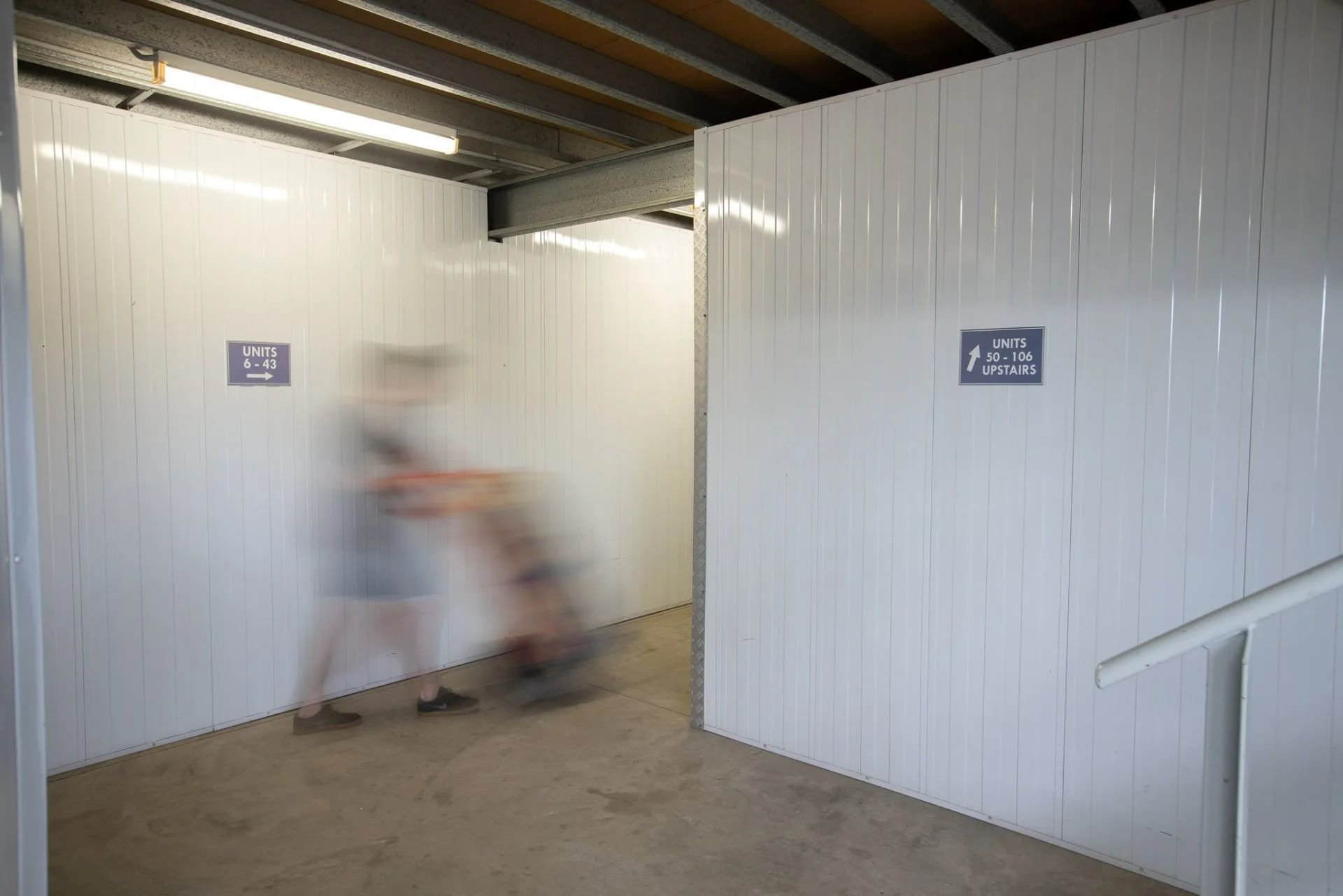 A Blurry Picture of a Person Pushing a Cart in a Room — AKM Self Storage In Kurri Kurri, NSW