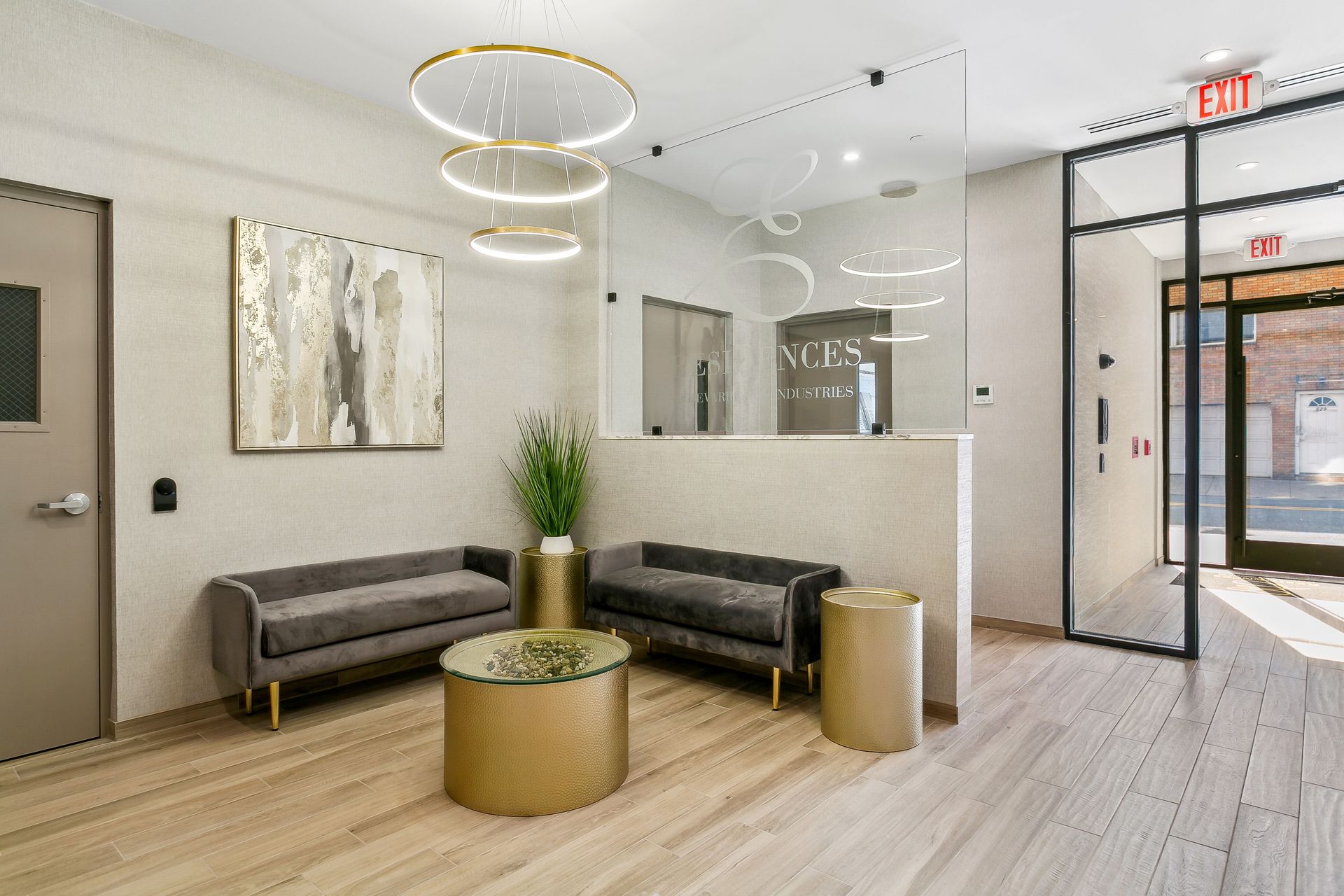 A lobby with a couch , table , and painting on the wall.