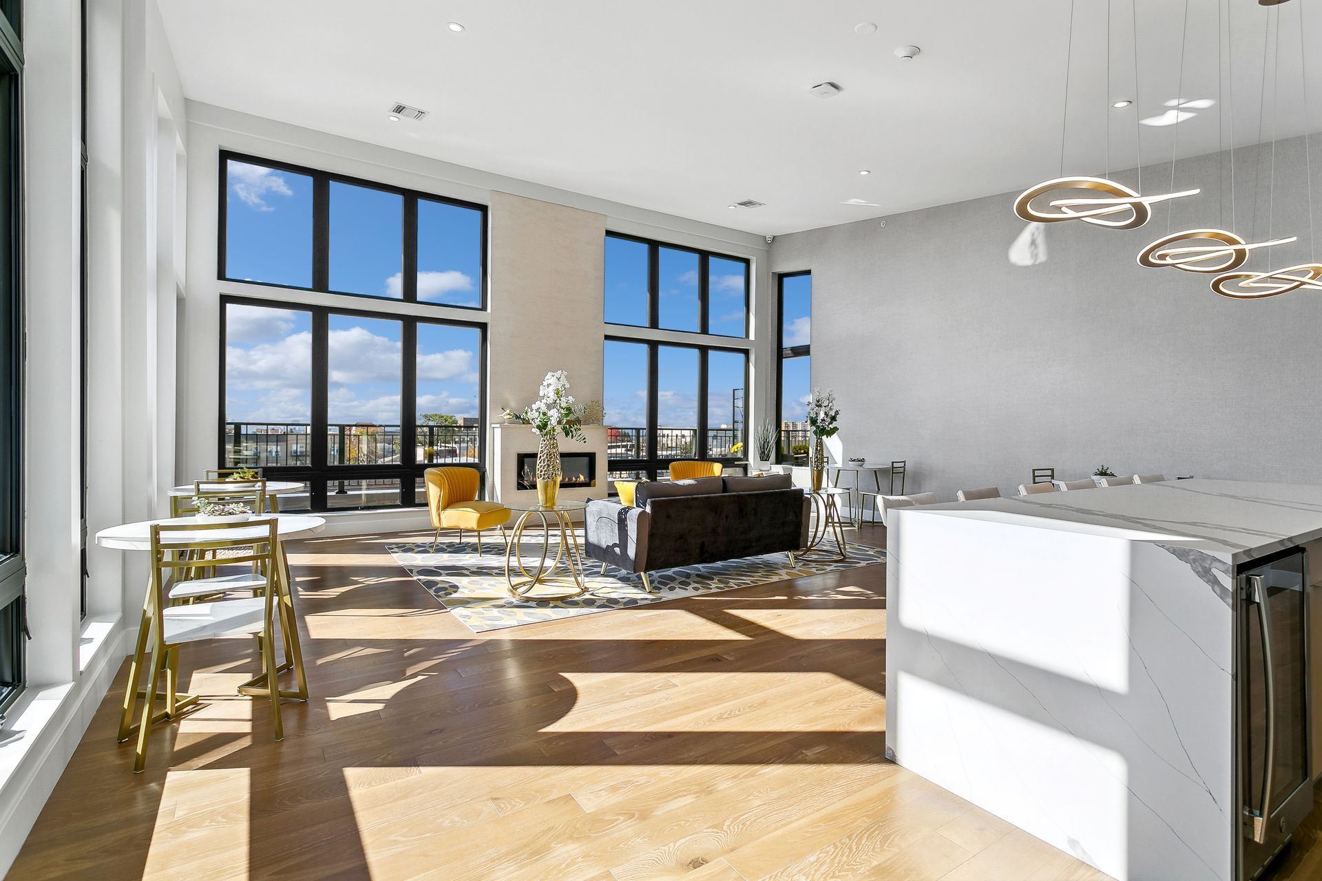 A large living room with a lot of windows and a kitchen.