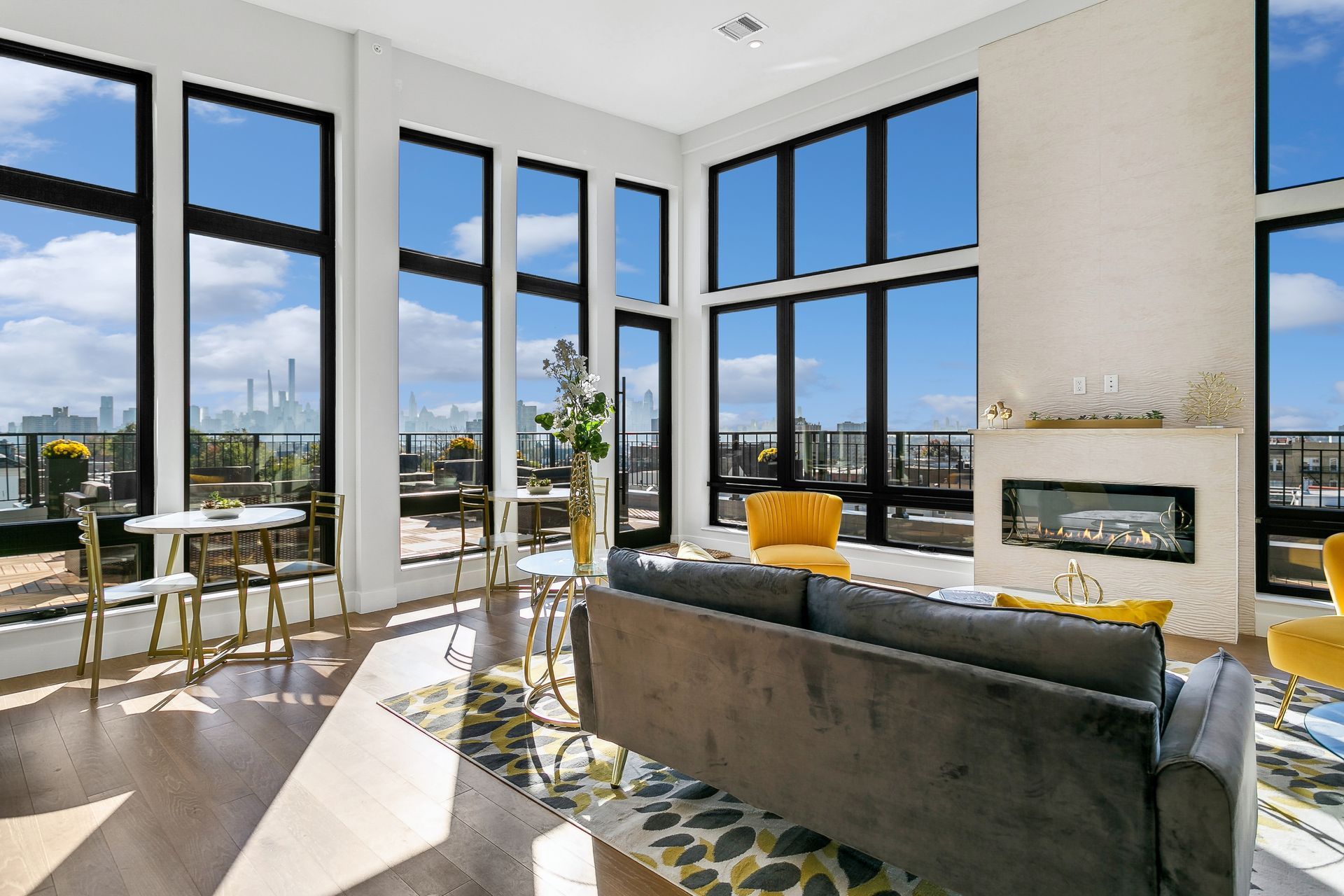 A living room with a couch , chairs , tables and a fireplace.