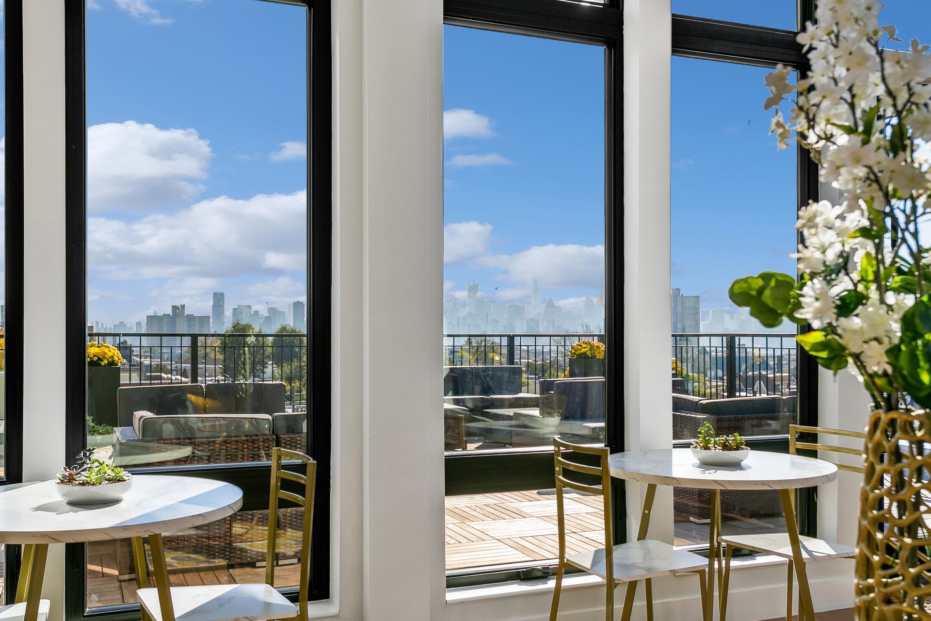 A living room with a table and chairs and a view of a city.