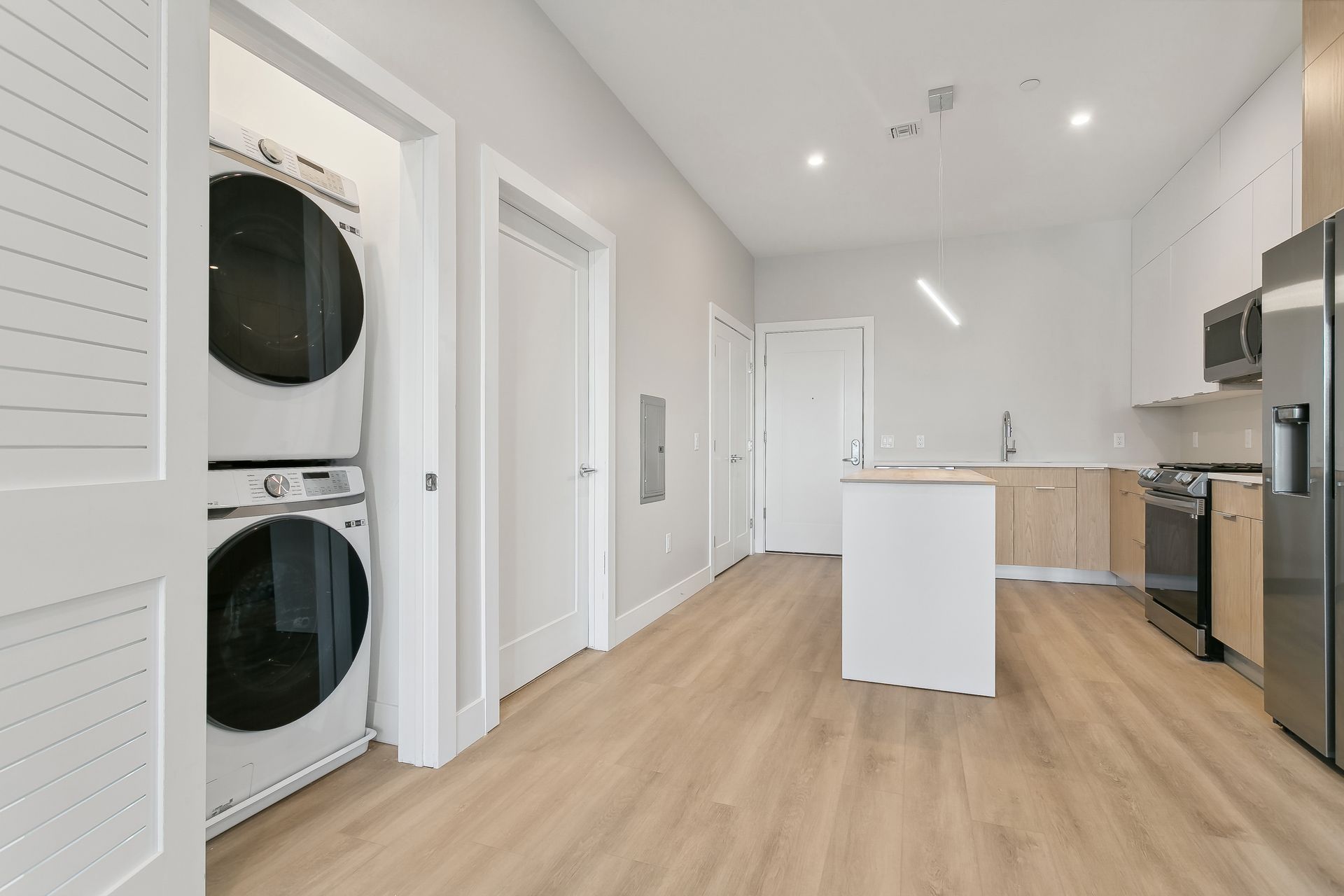 A kitchen with a washer and dryer stacked on top of each other