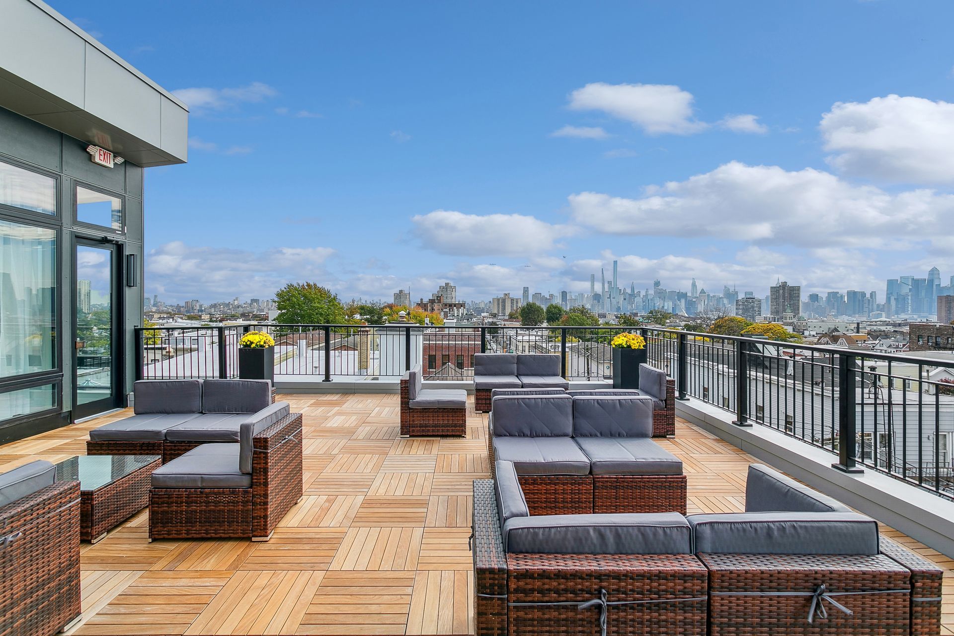 A rooftop deck with a lot of furniture and a view of the city.