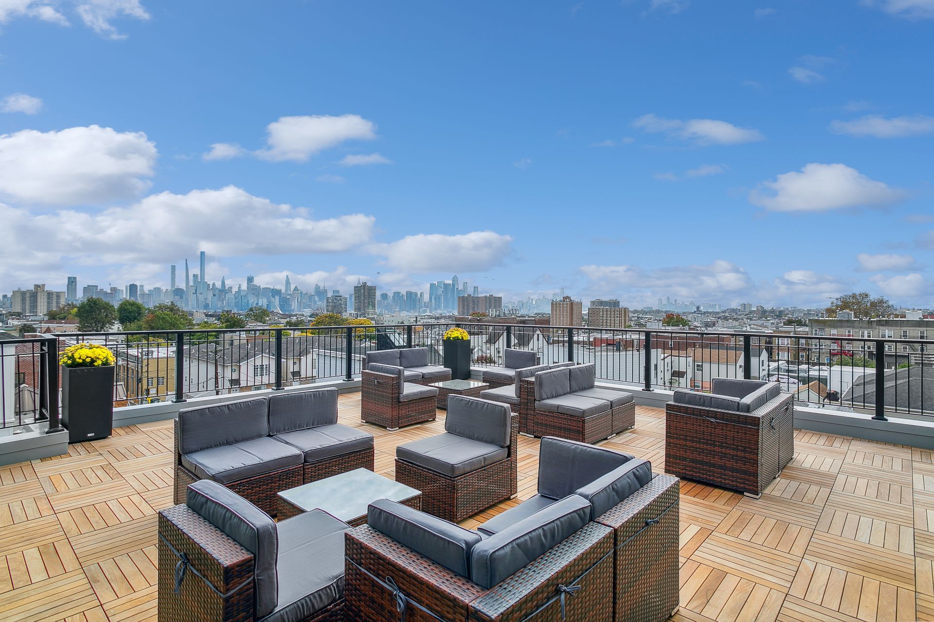 A rooftop deck with lots of furniture and a view of the city.