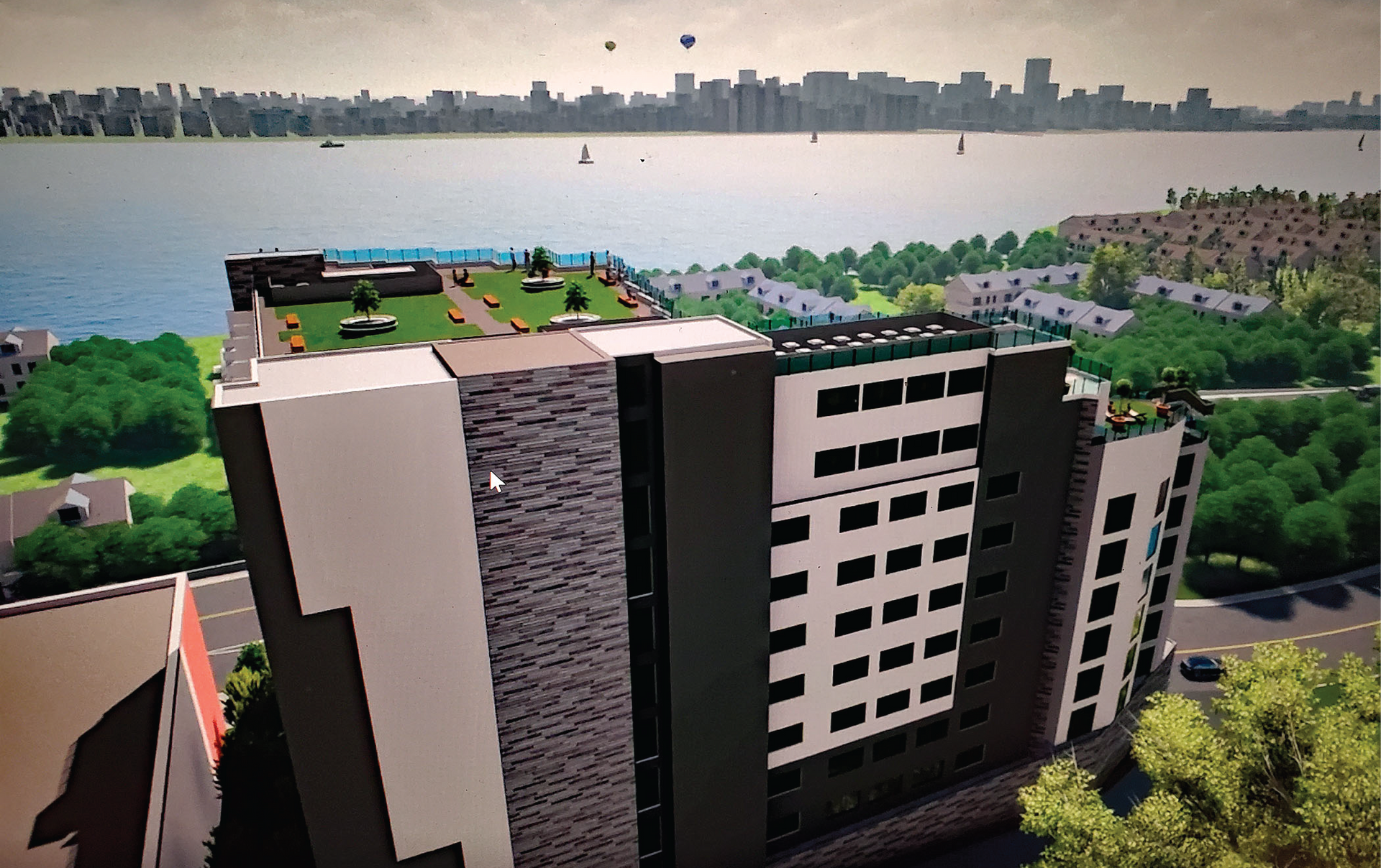 An aerial view of a building with a green roof overlooking a body of water.