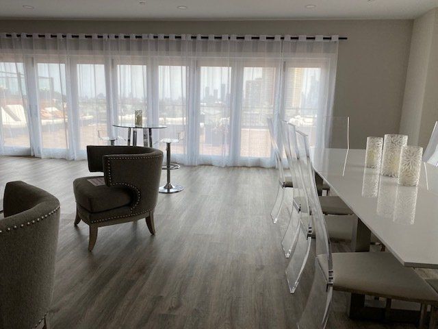 A living room with a table and chairs and a large window