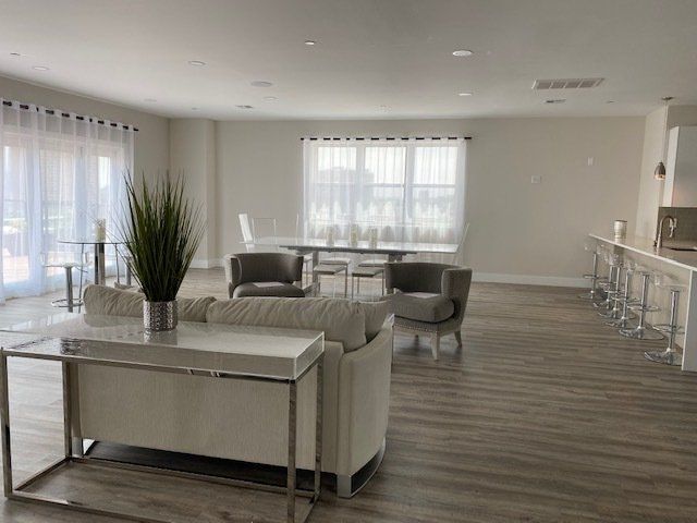 A living room with a couch , chairs , and a table.