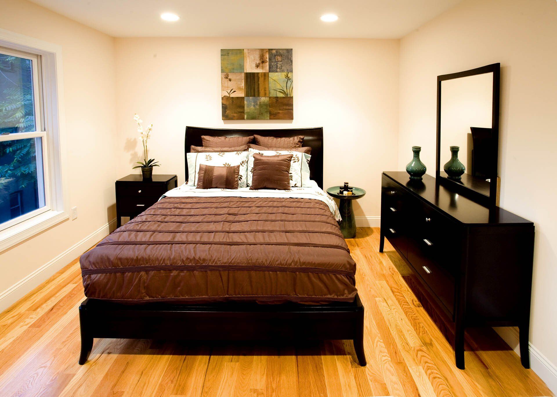 A bedroom with a bed dresser and mirror