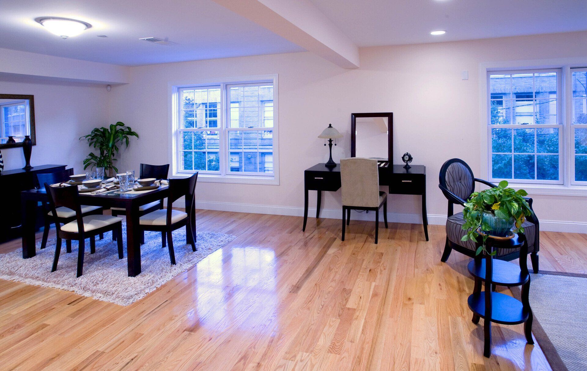 A living room with a dining table and chairs and a desk