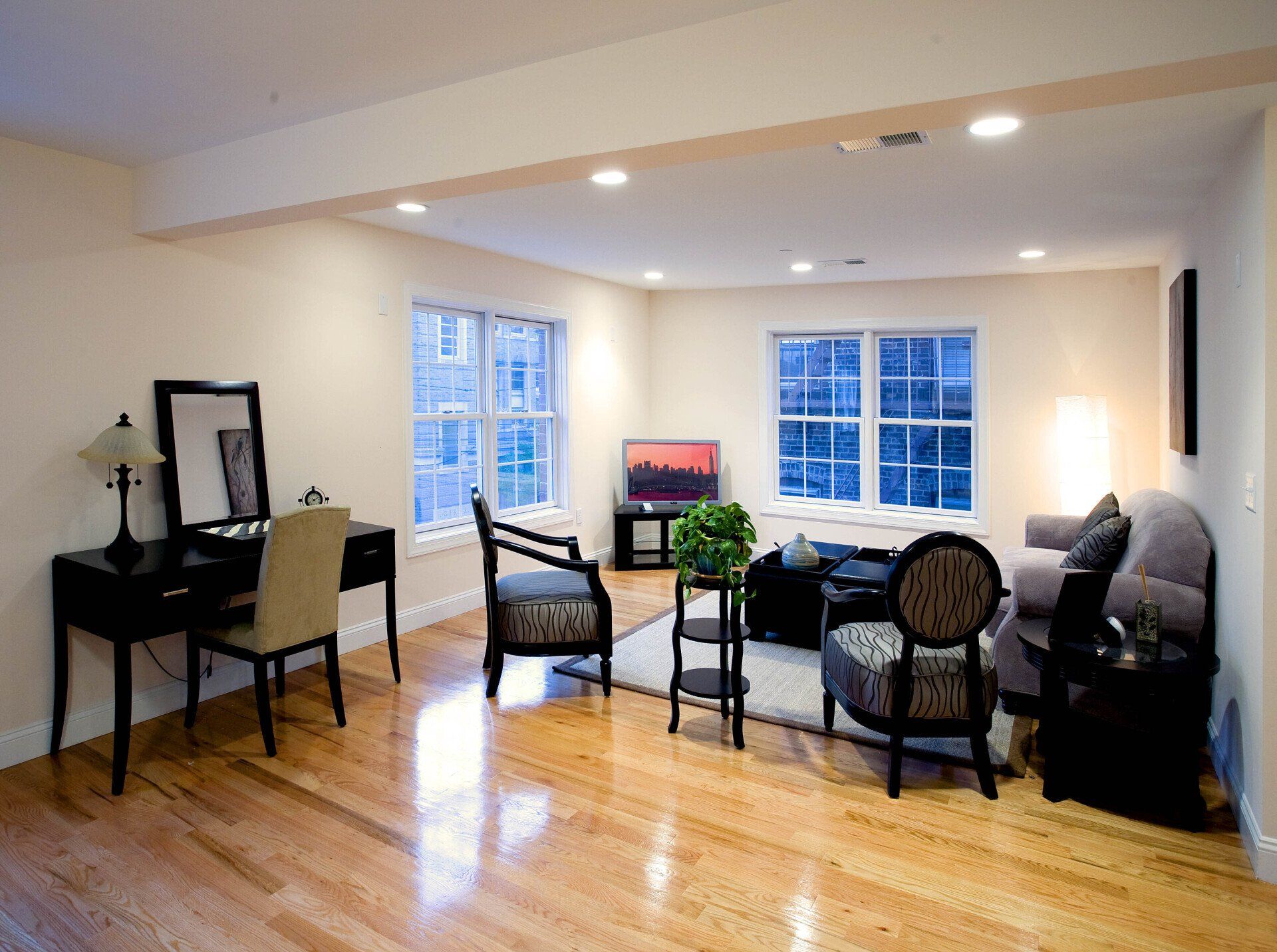 A living room with hardwood floors and a desk