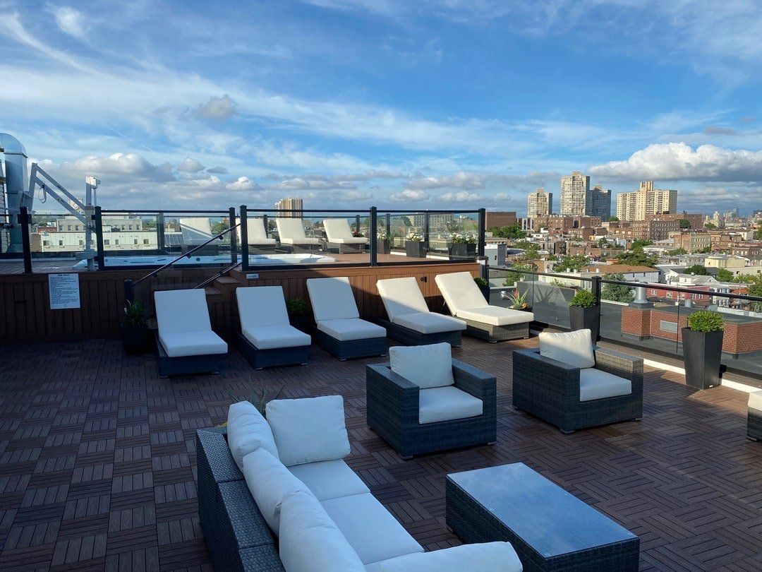 A rooftop patio with a couch , chairs and tables
