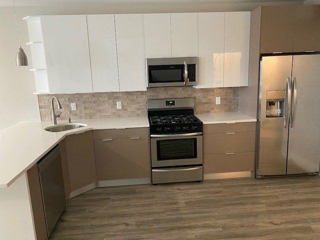 A kitchen with stainless steel appliances and white cabinets