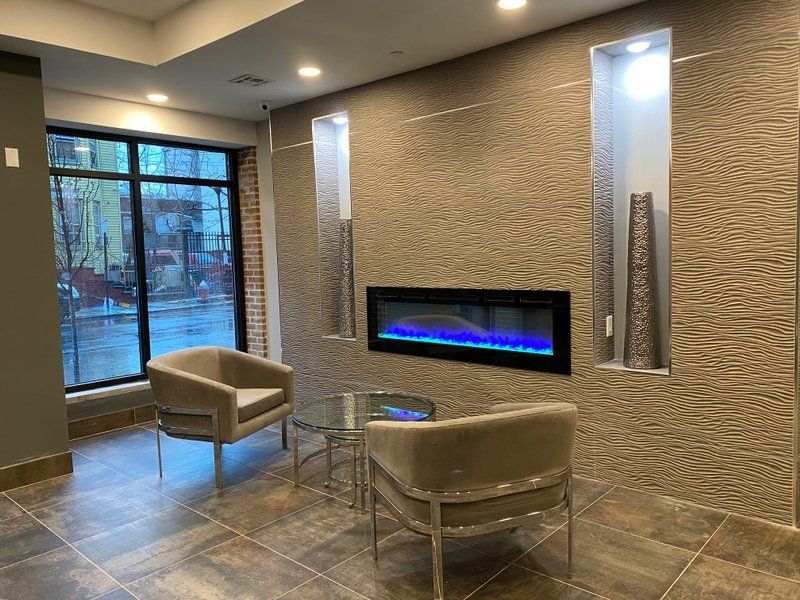 A living room with chairs , a table and a fireplace.