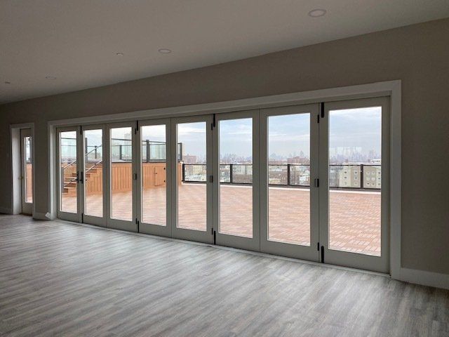 An empty room with a lot of windows and a balcony