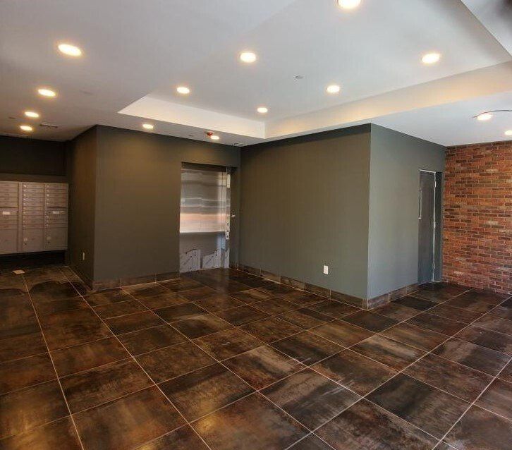 An empty room with brown tiles and a brick wall
