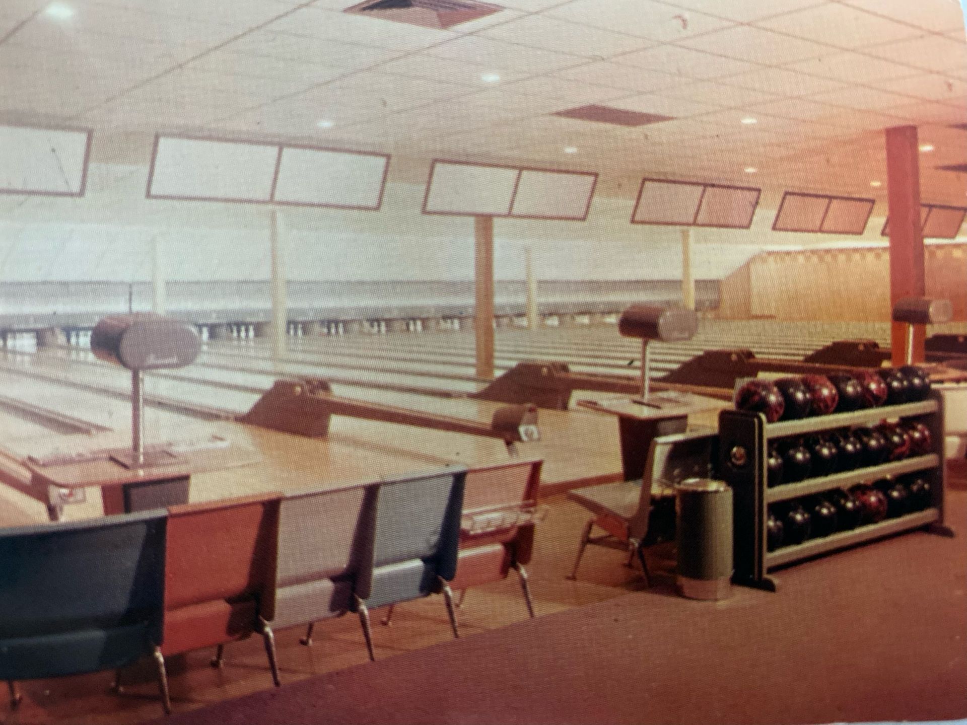 A bowling alley with a lot of chairs and bowling balls